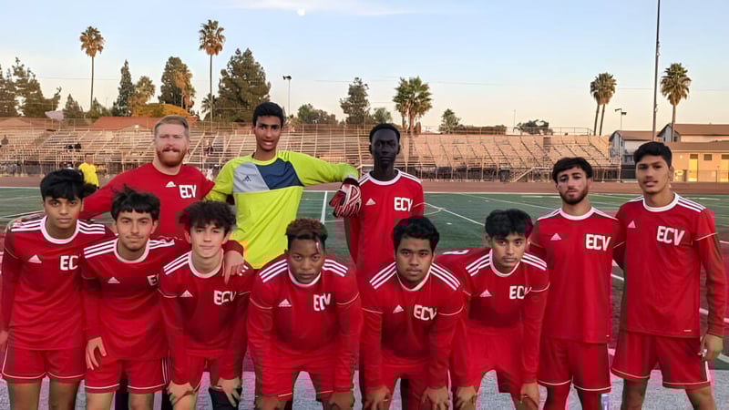 Eine Gruppe junger Fußballspieler in roten Trikots posiert gemeinsam auf dem Spielfeld der El Cajon Valley High School.
