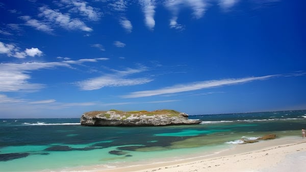Eine tropische Strandlandschaft mit einer felsigen Insel im Vordergrund, aufgenommen in der Nähe der Elanora State High School.