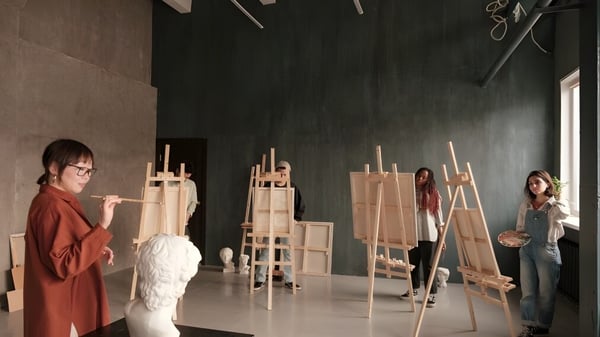 Schüler der Elite Preparatory Academy arbeiten im Kunstunterricht an Staffeleien in einem Studio.