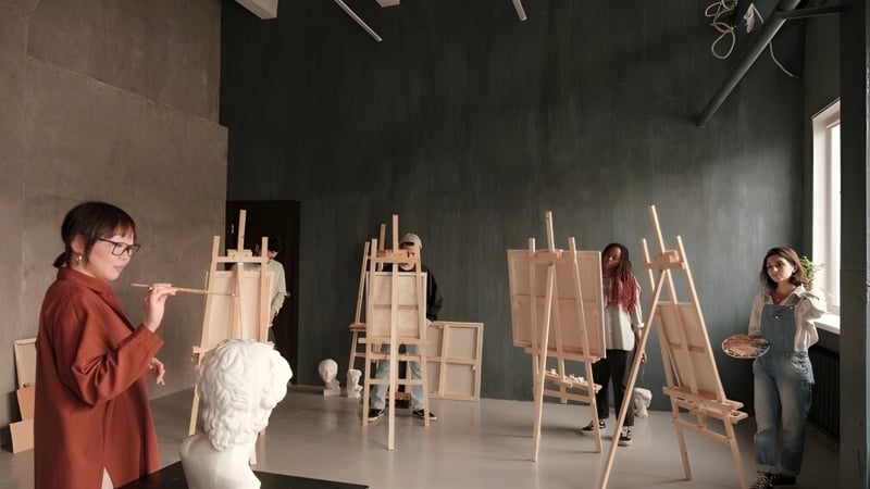 Schüler der Elite Preparatory Academy arbeiten im Kunstunterricht an Staffeleien in einem Studio.