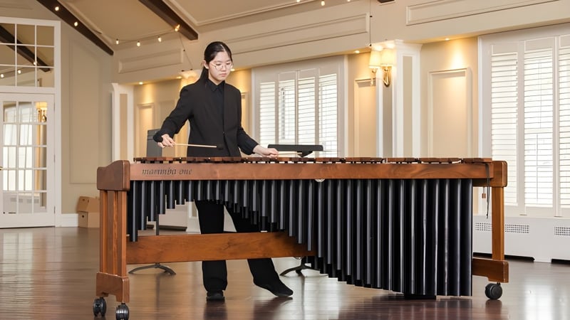 Eine Person spielt ein großes Holzmarimbafon im eleganten Raum der Elite Preparatory Academy.