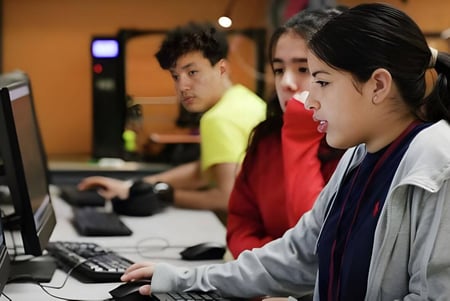 Schüler der Elmwood High School arbeiten gemeinsam im Computerraum an verschiedenen Aufgaben.