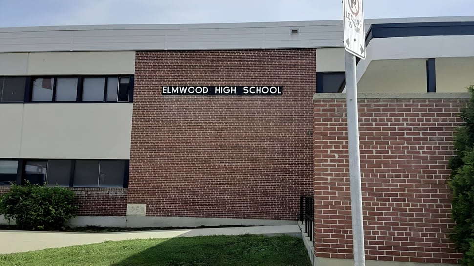 Das Backsteingebäude mit dem Schriftzug Elmwood High School ist von einer Grünfläche umgeben.