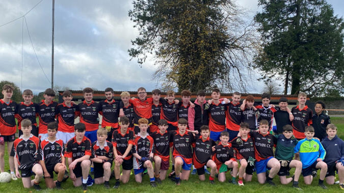 Eine Gruppe Schülerinnen und Schüler spielt und posiert gemeinsam auf dem Fußballfeld des Elphin Community College.