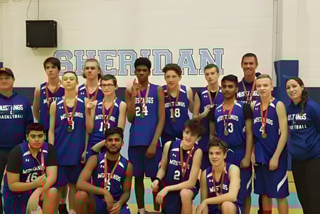 Eine Gruppe von Schülern der Elsie MacGill Secondary School posiert in der Sporthalle vor einem Sheridan-Schild.