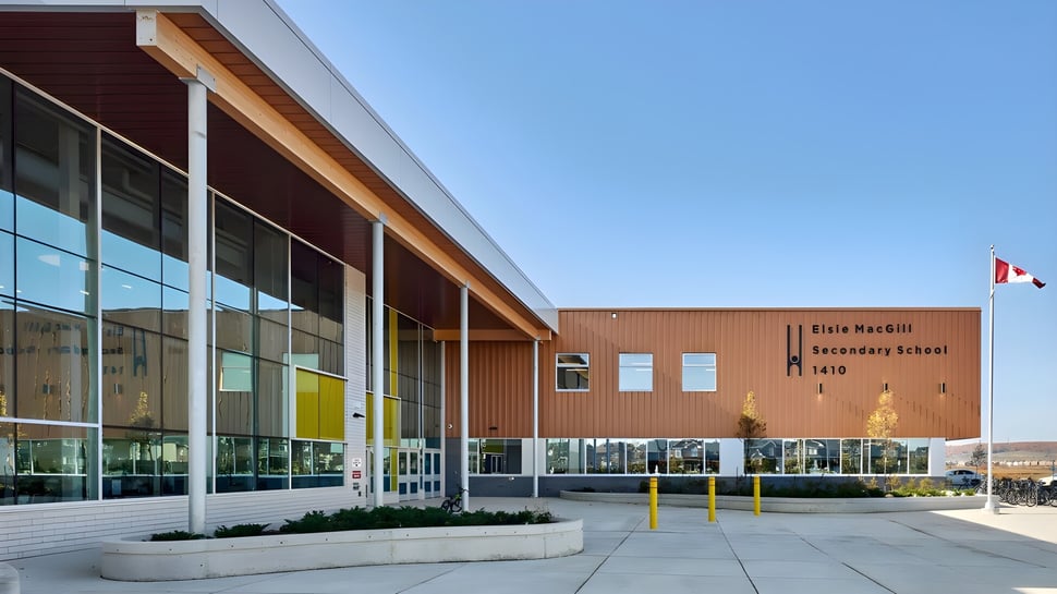 Das moderne Schulgebäude der Elsie MacGill Secondary School mit großen Glasfenstern unter klarem Himmel.