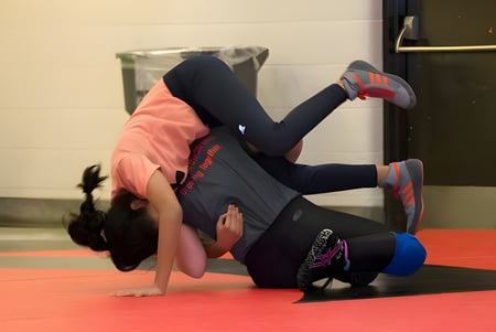 Eine Schülerin des Emery Collegiate Institute macht einen Handstand auf einer roten Matte im Fitnessstudio.