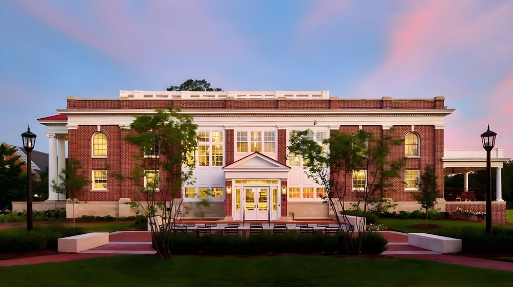 Das Backsteingebäude mit Säuleneingang steht auf dem Campus der Episcopal High School und ist von grünen Bäumen umgeben.