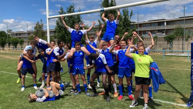Schüler der Episcopal Sem' De Walbourg feiern gemeinsam auf dem Sportplatz in ihren blauen Uniformen.