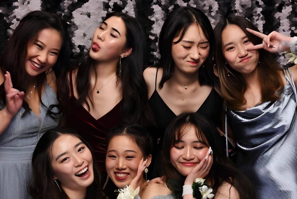 Eine Gruppe junger Schülerinnen der Epsom Girls Grammar School posiert gemeinsam vor einem schimmernden Vorhang.