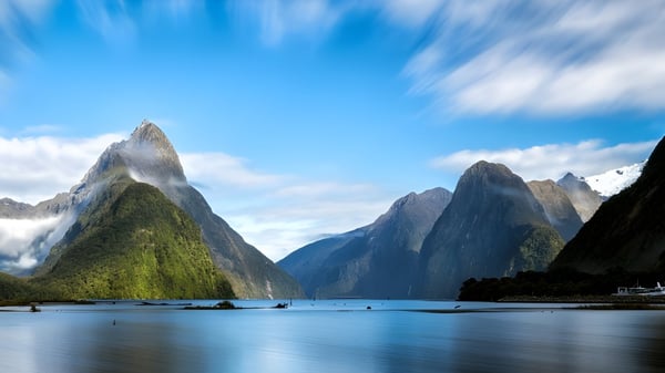 Blick auf schneebedeckte Berge und einen ruhigen See mit kleinen Booten nahe der Epsom Girls Grammar School.