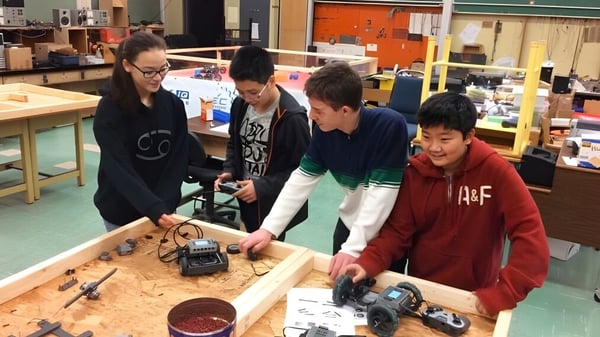 Schüler der Eric Hamber Secondary School untersuchen elektronische Bauteile an einem Werkbank im Unterricht.