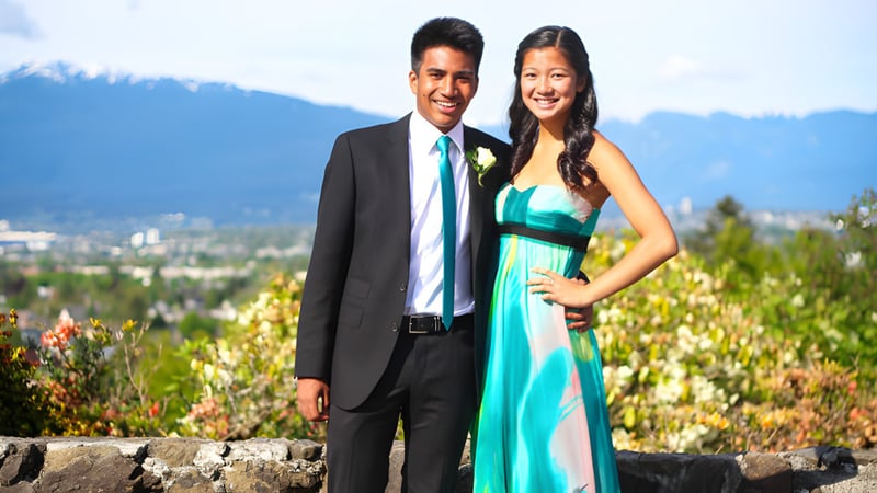 Ein Paar steht vor einem Bergpanorama auf dem Gelände der Eric Hamber Secondary School.