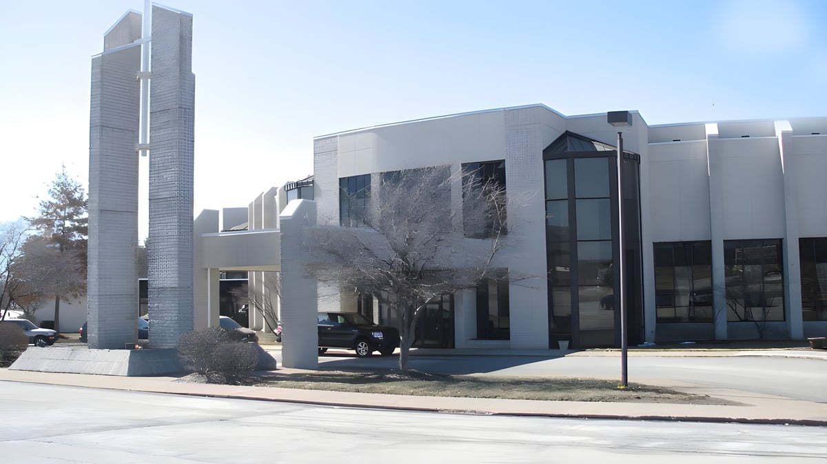 Das moderne mehrstöckige Gebäude der Erie First Christian Academy steht vor Bäumen unter klarem blauem Himmel.