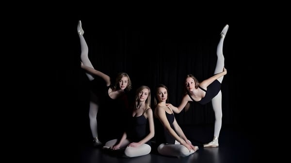 Vier weibliche Tänzerinnen führen eine synchronisierte akrobatische Routine auf der Bühne der Ernest Manning High School auf.