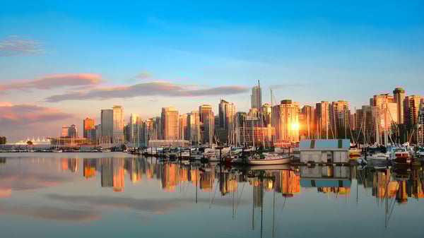 Ein malerisches Stadtbild mit hohen Wolkenkratzern am Wasser in der Nähe von Ernest Manning High School bei Sonnenuntergang.
