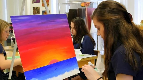 Schueler der Ernestown Secondary School arbeiten gemeinsam an einem farbenfrohen abstrakten Landschaftsgemälde im Kunstraum.