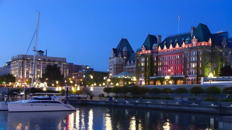 Der Blick von der Esquimalt High School zeigt eine Marina mit Booten vor der beleuchteten Stadt.