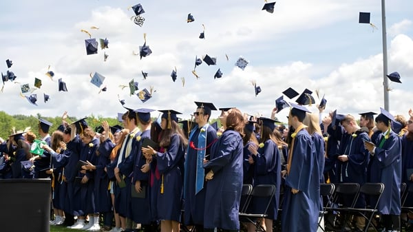 Eine Gruppe von Absolventinnen und Absolventen der Essex District High School wirft ihre Hüte während der Abschlussfeier in die Luft.