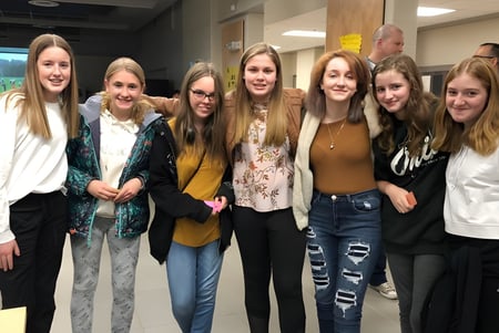 Eine Gruppe lächelnder Schülerinnen steht gemeinsam im Flur der Essex District High School.