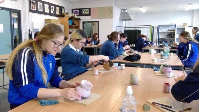 Schüler der Eureka Secondary School sitzen in der Klasse und sind mit verschiedenen Aktivitäten beschäftigt.