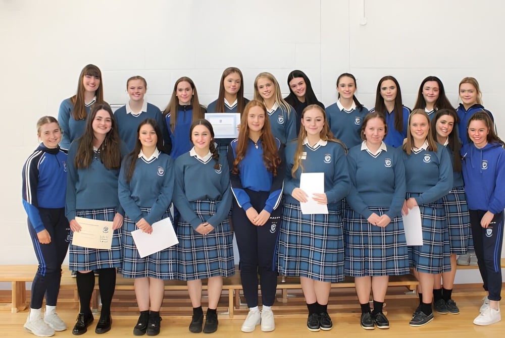 Eine Gruppe junger Schülerinnen steht in einer Klasse auf dem Campus der Eureka Secondary School.