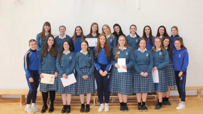 Eine Gruppe von Schülerinnen der Eureka Secondary School steht gemeinsam in einem Klassenraum.