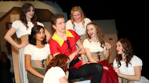 Eine Gruppe Schüler der Evan Hardy Collegiate steht auf einer Bühne in verschiedenen Outfits während einer Aufführung.