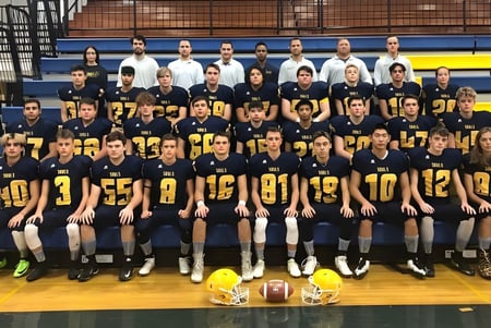 Schüler des Evan Hardy Collegiate versammeln sich in einer Sporthalle mit Sportausrüstung.