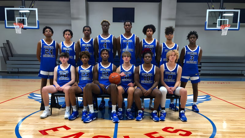 Eine Gruppe von Schülerinnen und Schülern der Evangel Christian Academy posiert gemeinsam auf dem Basketballfeld mit Basketballkörben im Hintergrund.