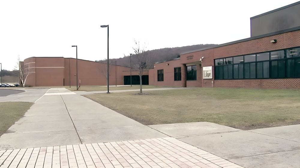 Das Backsteingebäude mit großen Fenstern und umliegendem Weg der Fabius Pompey High School.