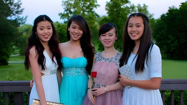 Vier Schülerinnen der Fairfax Christian School stehen auf einem Holzdeck umgeben von Bäumen und Grasflächen.