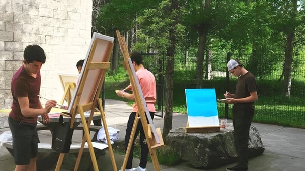 Schüler der Fernie Secondary School beteiligen sich an einer Outdoor-Malaktivität im grünen Wald.