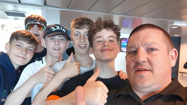 Eine Gruppe Schülerinnen und Schüler der Firrhill High School posiert gemeinsam in einem bunten Verkaufs- und Unterhaltungsumfeld.