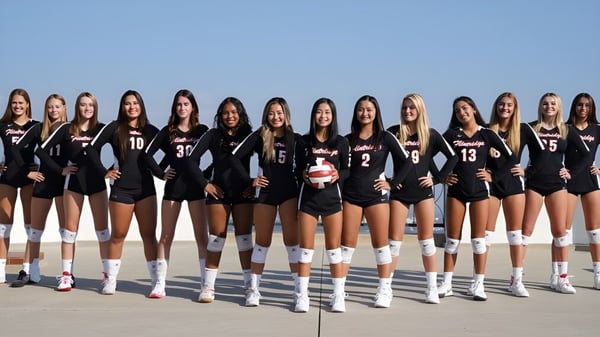 Eine Gruppe junger Volleyballspielerinnen steht in Uniform draußen vor klarem blauem Himmel auf dem Gelände der Flintridge Sacred Heart Academy.