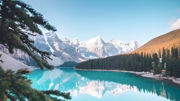 Ein türkiser Bergsee umgeben von schneebedeckten Bergen und immergrünen Wäldern auf dem Gelände der Forest Lawn High School.