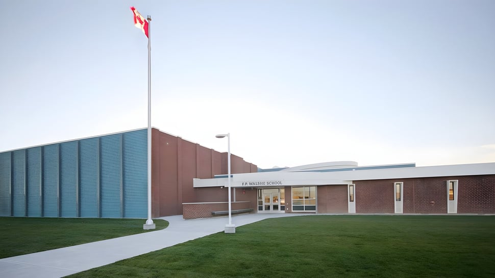 Das Backsteingebäude der F.P. Walshe School mit einer kanadischen Flagge auf dem Dach und einem Weg zum Eingang.