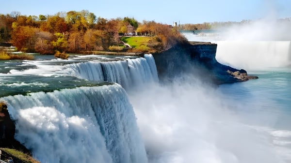 Ein Wasserfall fließt über einen felsigen Abhang vor herbstlichem Laub auf dem Gelände der F.P. Walshe School.