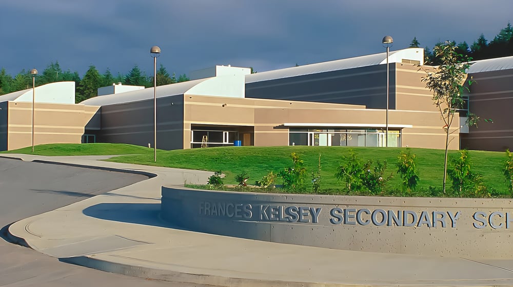 Das moderne Schulgebäude der Frances Kelsey Secondary School mit einem gestalteten Eingangsbereich ist zu sehen.