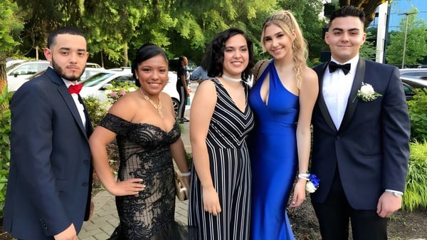 Fuenf gut gekleidete Personen posieren gemeinsam vor gruener Kulisse auf dem Campus des Fraser Coast Anglican College.