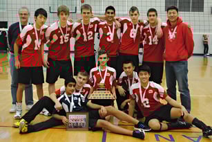 Eine Gruppe von Schülern der Fraser Heights Secondary School posiert mit einem Pokal in einer Sporthalle.