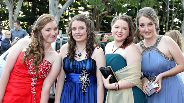 Vier Schülerinnen der Fraser Heights Secondary School posieren gemeinsam draußen vor grünem Baumhintergrund.