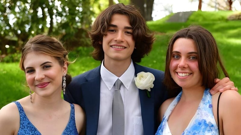 Drei Schüler der Frederick Gunn School posieren zusammen lächelnd in einer grünen Außenanlage.