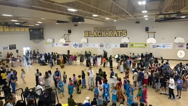 Viele Schüler versammeln sich in der Basketballhalle der Fredericton High School vor der Blackcats-Beschilderung.
