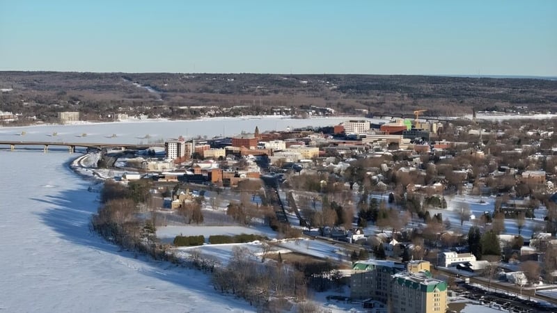 Verschneite Stadtansicht mit gefrorenem Fluss im Hintergrund der Fredericton High School.