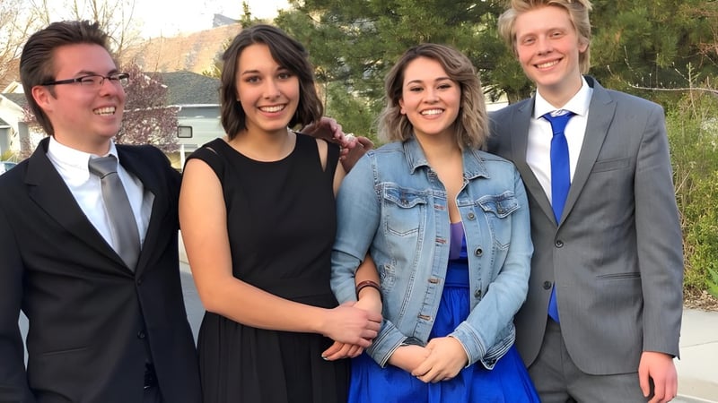 Vier Schüler der Freedom Preparatory Academy stehen im Freien vor einem Gebäude und lächeln zusammen.