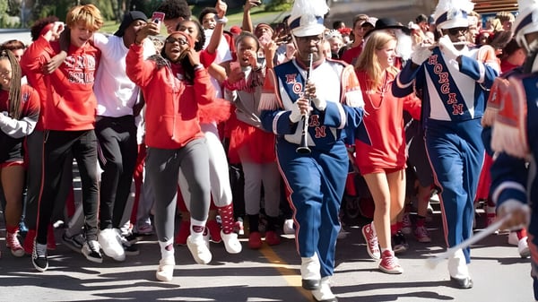 Eine Gruppe Schüler der Friends School of Baltimore nimmt an einer Parade teil und trägt überwiegend rot-weiße Kleidung.