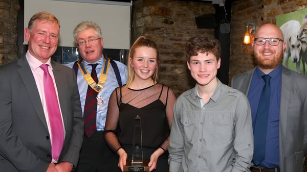 Fünf Personen, darunter zwei ältere Herren in Anzügen und eine junge Frau, posieren gemeinsam im Innenbereich von Frome College.