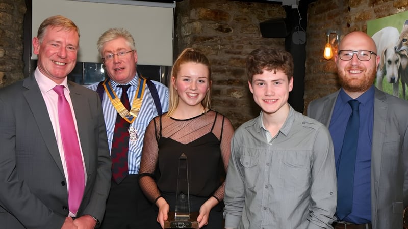 Fünf Personen, darunter zwei ältere Herren in Anzügen und eine junge Frau, posieren gemeinsam im Innenbereich von Frome College.