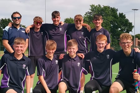 Eine Gruppe von Schülern in Sportuniformen posiert gemeinsam auf dem Sportfeld des Frome College.